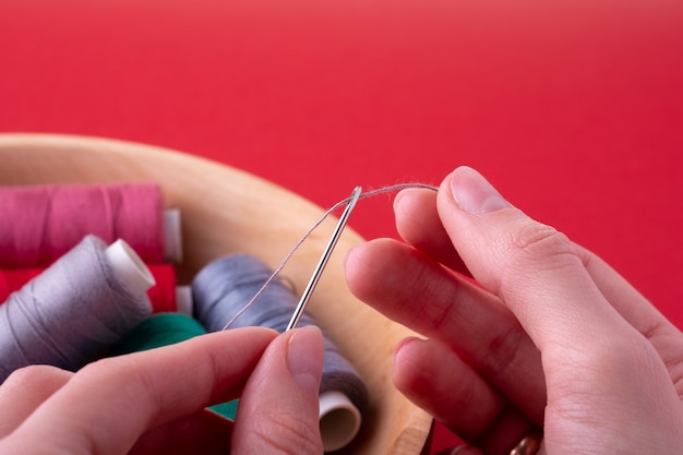 Ręce trzymają igłę i tkaninę